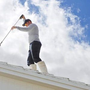 Handy man Pressure cleaning a roof.